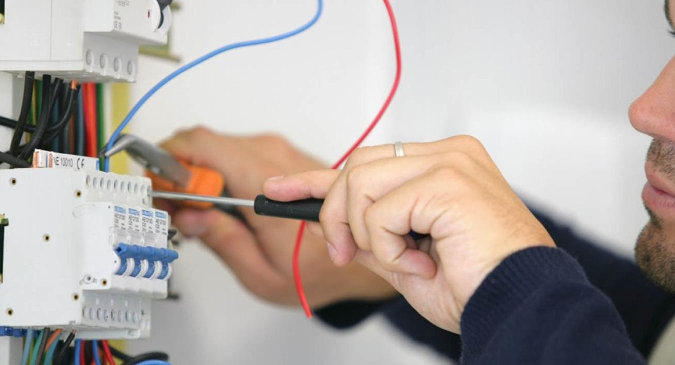 Electrician working on fuse board